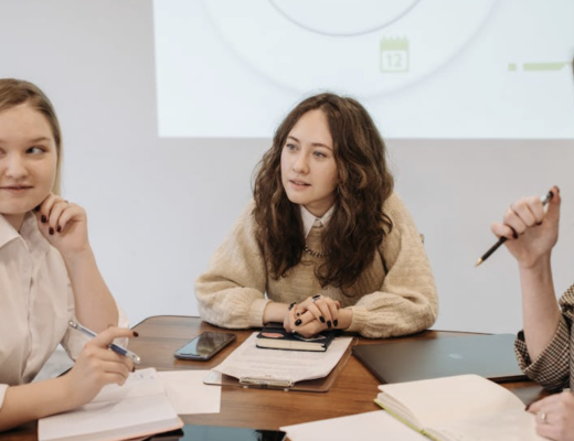 3 Young Professional Women Sitting Around a Conference Table